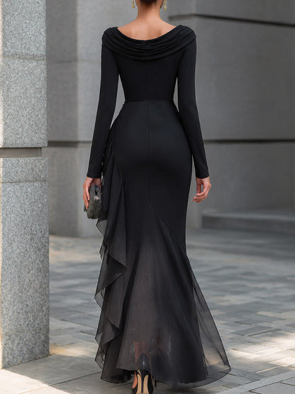 Vestido largo tipo sirena negro, con hombros descubiertos, cuello vuelto, mangas largas, volantes de gasa y corte drapeado