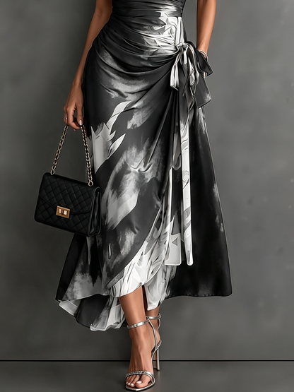 Vestido midi cruzado con estampado abstracto en rojo y negro, cuello en V, manga corta, lazo en la cintura y volantes en el bajo asimétrico