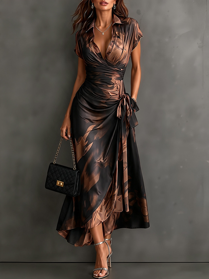 Vestido midi cruzado con estampado abstracto en tonos marrón y negro, cuello en V, manga corta, lazo en la cintura y volantes en el bajo asimétrico